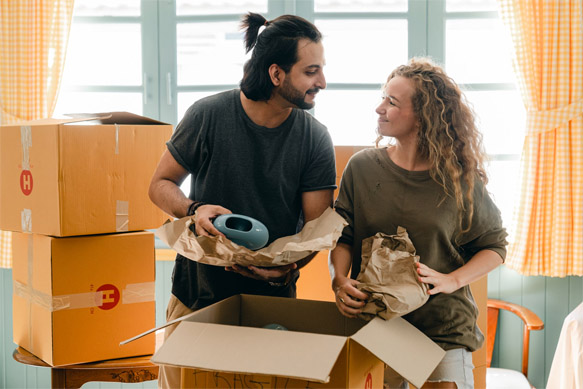 Joyful couple actively engaged in packing for their upcoming house removal, embracing the excitement of a new chapter.