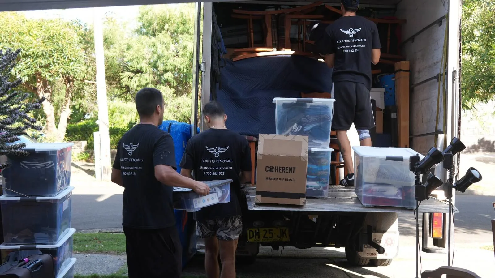 Atlantis Removals crew working efficiently together to load packed boxes and belongings into a moving truck in Newcastle.